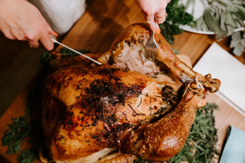 Golden roasted holiday turkey centerpiece with cranberry sauce, squash, and autumn herbs