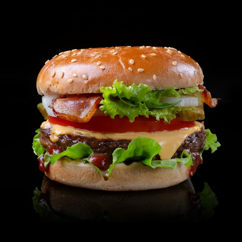 Gourmet double smash burger with melted sharp cheddar and artisan brioche bun on dark tray