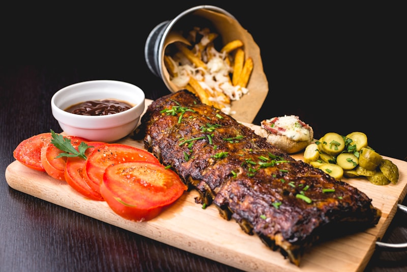 Hearty cast iron skillet with glazed ribs and comfort food sides in rustic tavern setting