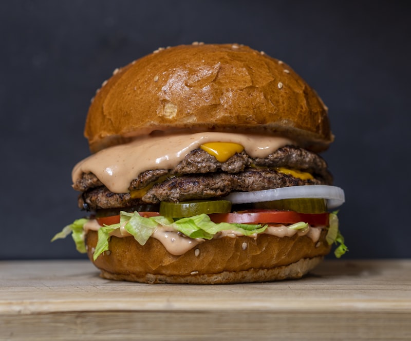 Classic fast food burger, crispy French fries, and refreshing beverage on modern diner tray