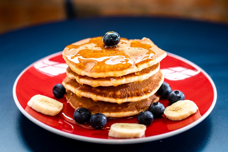 Crisp toasted golden protein waffles topped with butter pat, fresh strawberries, and pure maple syrup