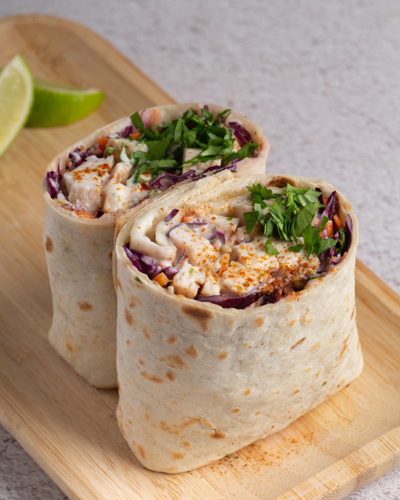 Golden toasted breakfast burrito sliced in half showing fluffy scrambled eggs and melted cheddar cheese