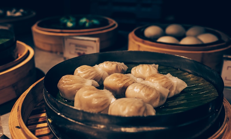 Steaming delicate Chinese soup dumplings in a bamboo steamer basket garnished with green onions